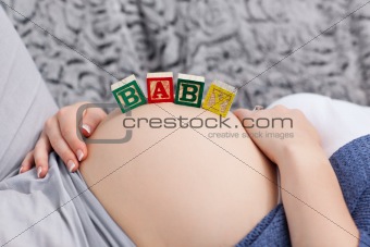 Pregnant young woman with cubes on her belly