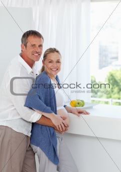 Young couple looking at the camera while they are hugging