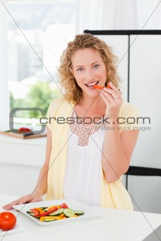 Beautiful woman is eating vegetables