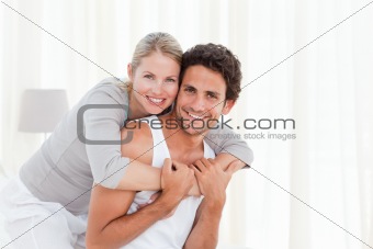Lovely couple hugging on their bed