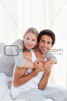 Lovely couple hugging on their bed