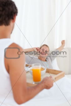 Man bringing the breakfast to his wife 