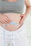 Close up of a woman measuring her belly