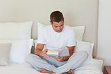 Man reading a book on the bed
