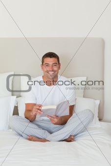 Man reading a book on the bed