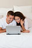 Lovely couple looking at their laptop 