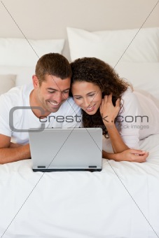 Lovely couple looking at their laptop 
