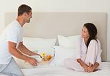 Man bringing the breakfast to his wife in bed