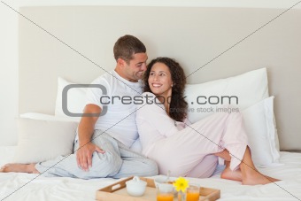 Couple having breakfast in their bed at home