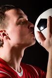 soccer player is kissing the ball