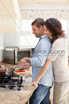 Woman hugging her husband while he is cooking