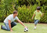 Son playing football with his father