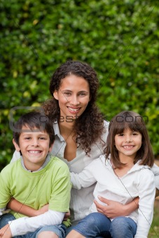 Mother with their children looking at the camera in the garden