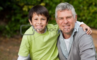 Grandfather with his grandson looking at the camera in the garde