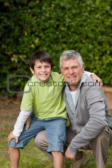 Grandfather with his grandson looking at the camera in the garden