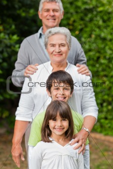 Grandparents with their children looking at the camera in the ga