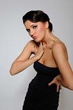 Beautiful fashion model in black dress with evening hairstyle