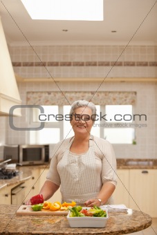 Retired woman looking at the camera in the kitchen