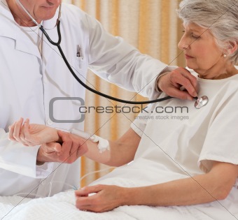 Senior doctor taking the heartbeat of his patient