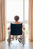 Mature woman in her wheelchair with her back to the camera 