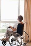 Senior woman in her wheelchair looking out the window