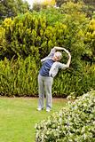 Retired  woman doing her streches in the garden