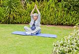 Mature woman doing her stretches in the garden