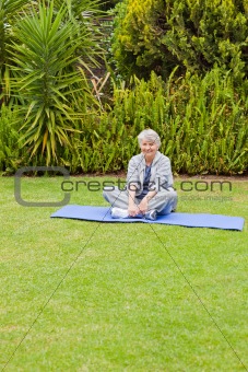 Senior woman doing her streches in the garden