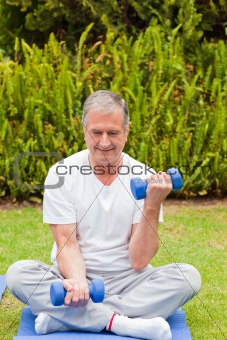 Retired man doing his exercises in the garden