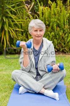 Retired woman doing her exercises in the garden