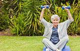 Retired woman doing her exercises in the garden