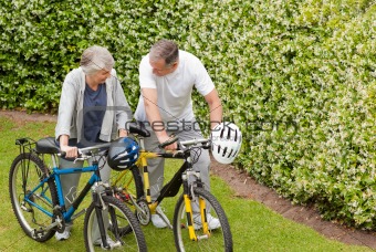 Mature couple walking with their bikes