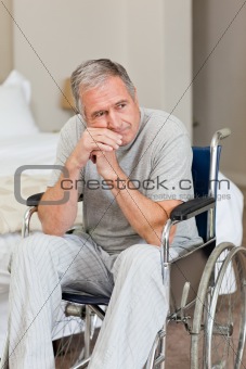 Smiling senior man in his wheelchair  at home