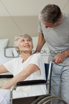 Retired woman in her wheelchair with her husband