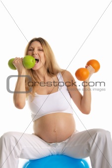 Pregnant woman bites dumbbell fruit
