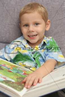 The happy boy holds the greater book in hands