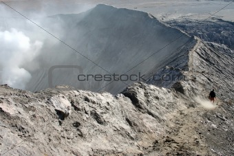 Lonely man walking on the edge of volcano