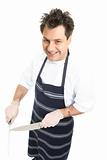 Smiling butcher or chef sharpens knife