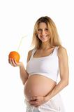 pregnant woman holding orange with straw
