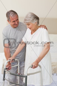 Man helping his wife to walk