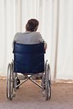 Mature man in his wheelchair with his back to the camera
