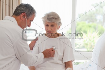 Senior doctor taking the heartbeat of his patient