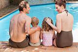 Happy family beside the swimming pool
