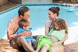 Portrait of a happy family beside the swimming pool