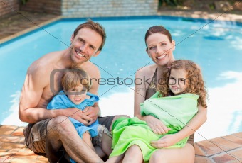 Portrait of a happy family beside the swimming pool