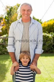 Grandather and his grandson looking at the camera in the garden