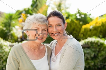 Mother with her daughter looking at the camera in the garden