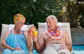 Happy senior couple drinking cocktails and toasting each other 