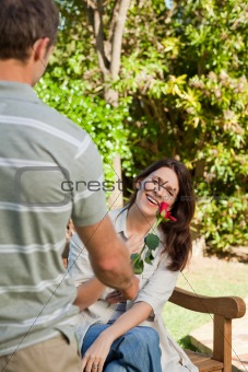 Man offering a rose to his wife