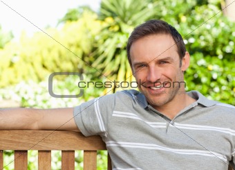 Portrait of a man sitting on a  bench 